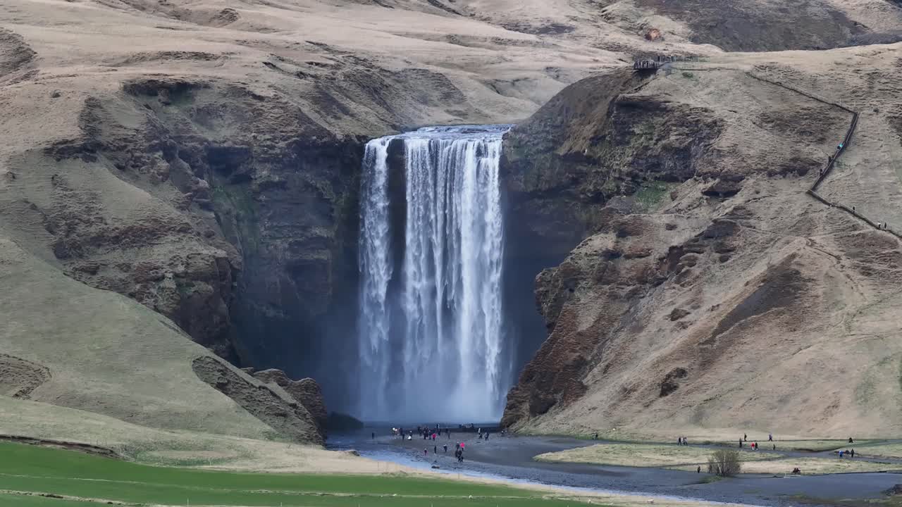 la cascada de skogafoss, una majestuosa maravilla natural, atrae a innumerables viajeros a su pintoresco entorno, enclavado entre las escarpadas montañas de islandia y los paisajes esmeraldas, la cascada de skogafoss