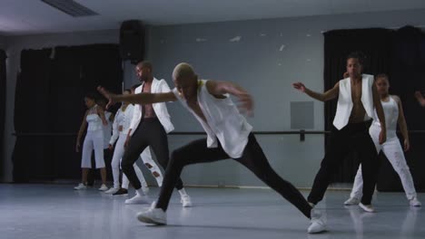 grupo multiétnico de bailarines modernos hombres y mujeres en forma practicando una rutina de baile