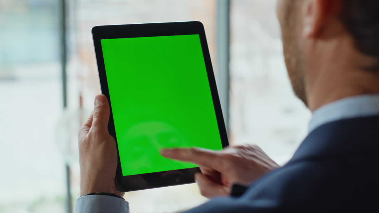 Financier hand tapping green screen tablet browsing account in office closeup