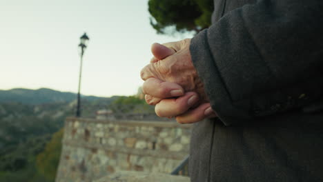 hands of an elderly man impatiently ticking the passage of time in rural village