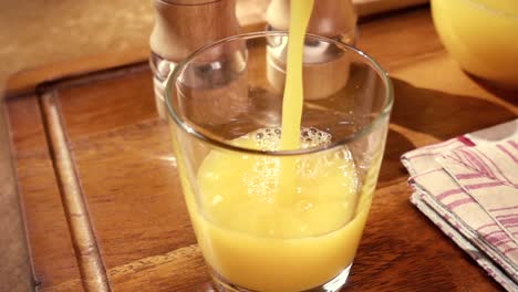 Jugo-De-Naranja-Vertido-En-Un-Vaso,-El-Desayuno-De-La-Mañana.-Cámara-Lenta-Con-Seguimiento-De-Rotación.