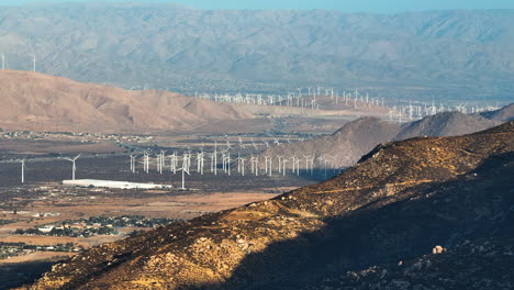 telephoto drone shot approaching a wind farm, sunset in palm desert, ca, usa