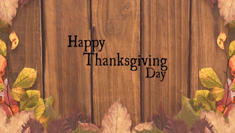 Animation-of-happy-thanksgiving-day-text-over-wooden-background-with-autumn-leaves