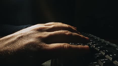man is typing on a keyboard.