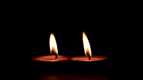 two butterlamp candles burning in the dark. traditional butterlamp glowing in the dark