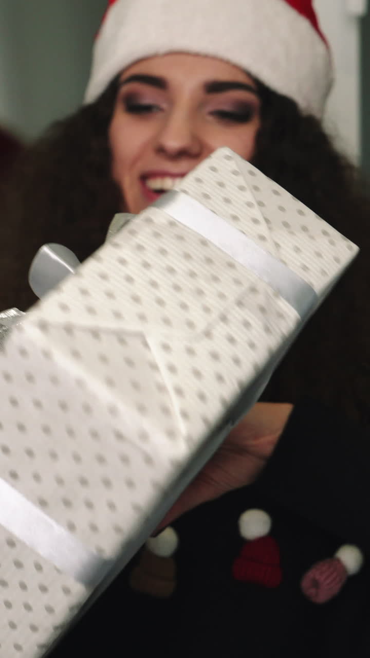 Women exchanging gifts. Smiling young women exchanging gifts on Christmas holiday at home Vertical video