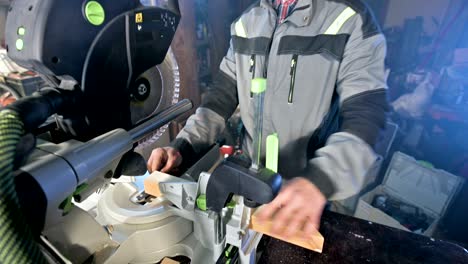 a young carpenter installs a wooden work piece in a circular sawing machine.