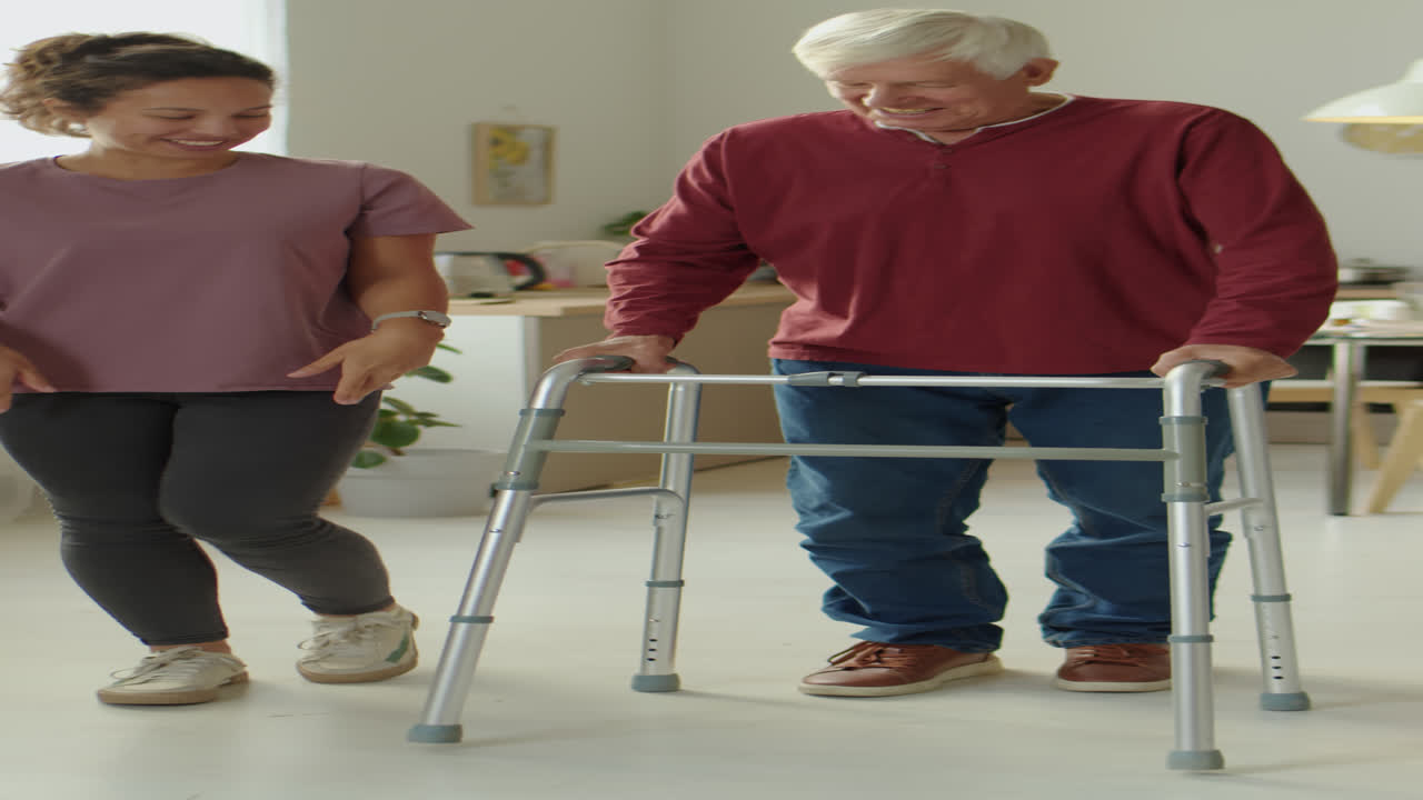 Caregiver and Senior Man Walking around House with Walker