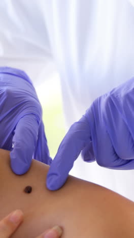 woman therapist pointing a mole of her patient