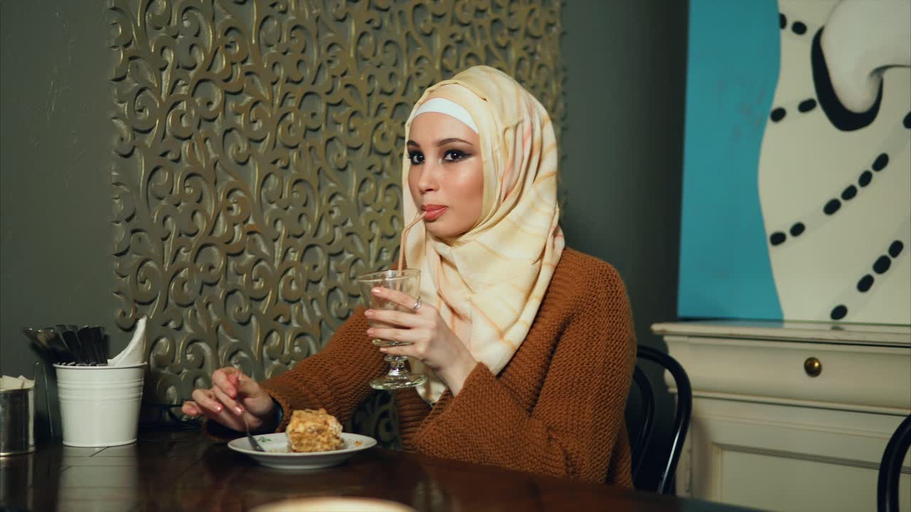Woman eating cake and drinking in a cafe