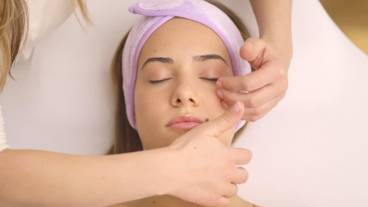 mujer recibiendo un masaje facial en un spa
