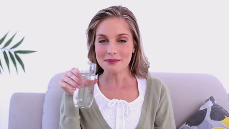 mujer tranquila bebiendo un vaso de agua