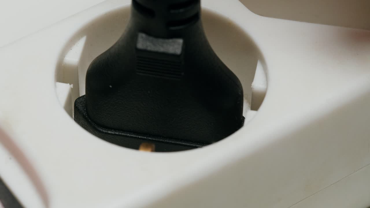 Close-up of a power plug inserting into an electrical outlet