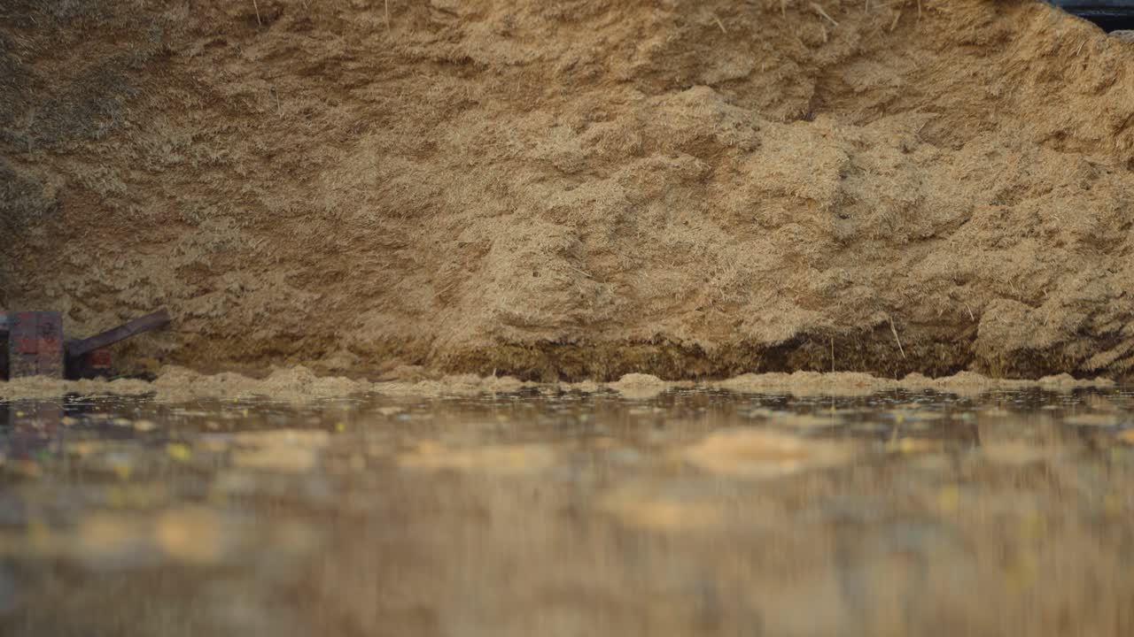 Static close-up video at water level looking up towards a dirt wall amidst the flood in Jalalpur Pirwala