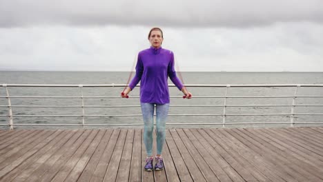 Junge-Frau-Trainiert-Am-Springseil.-Outdoor-Sportarten.-Mädchen-Springt-Auf-Einem-Springseil-Am-Meer.-Zeitlupenaufnahme