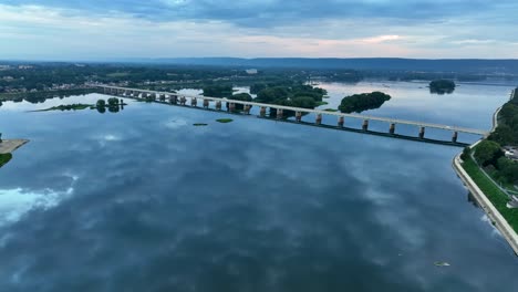 cinematic aerial of long bridge over river in usa