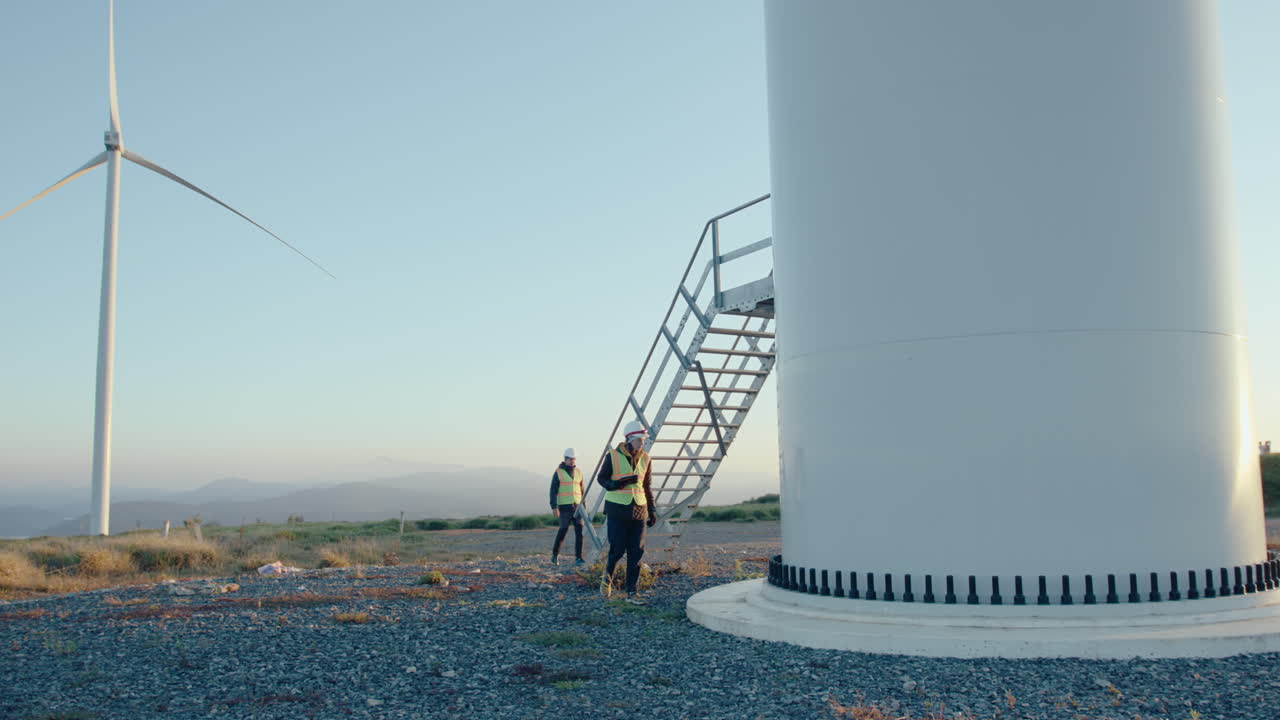 Male and Female Technicians Inspecting Wind Turbines