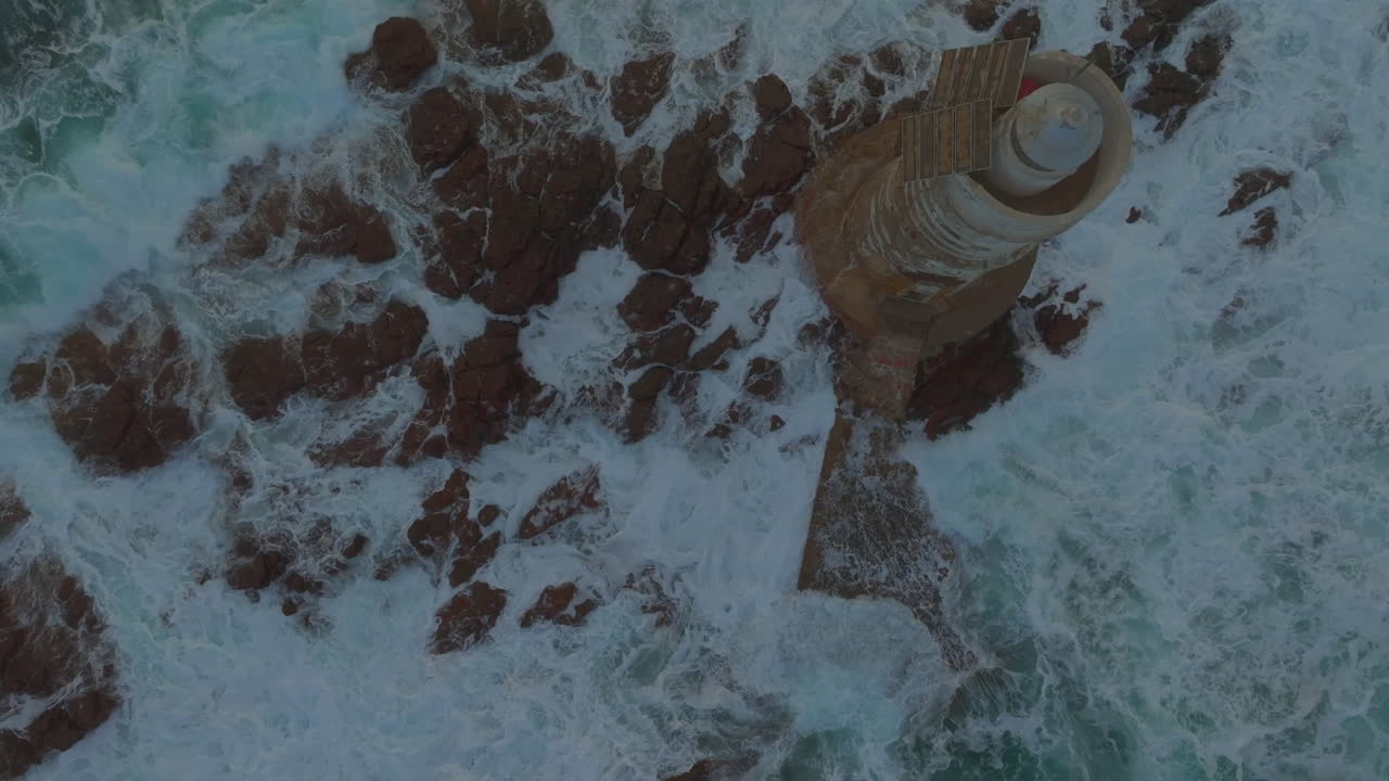 Mangiabarche Lighthouse, Sardinia: Fantastic aerial view from above discovering the beautiful lighthouse and the fury of the waves during the sunset