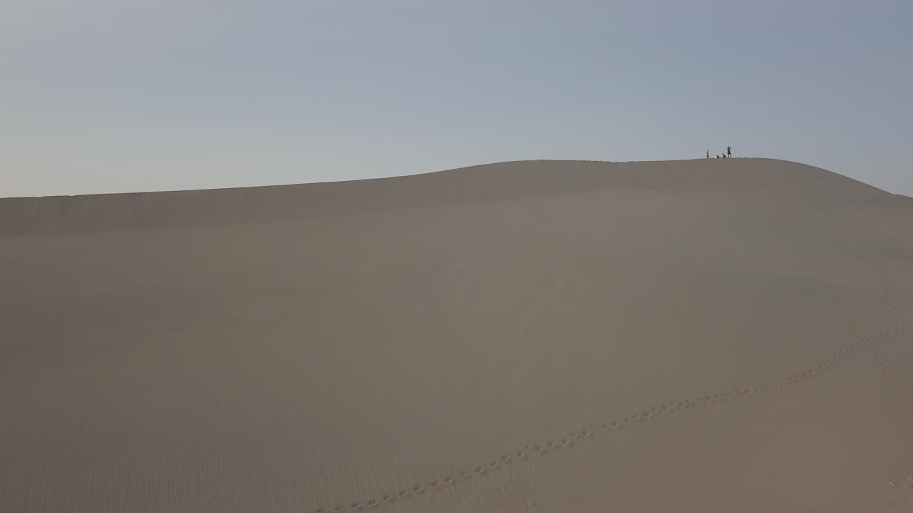 죽음의 계곡에서 모래 언덕을 걷는 사람들의 공중 드론 샷