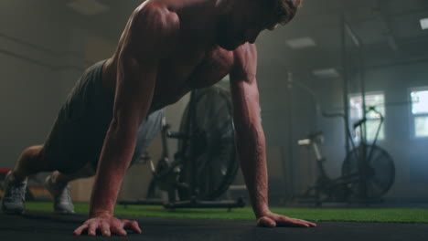 Man-doing-push-ups-in-a-gym.-Exhaling-and-inhaling-after-push-ups-and-exercise.-Perfect-for-fitness-and-workout.-Young-sports-man-performs-pushups-in-the-gym.-The-athlete-is-engaged-in-fitnes