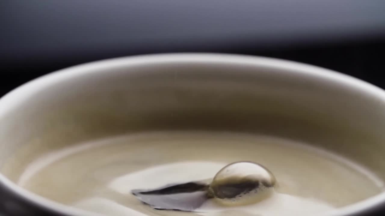 검은 커피는 느린 동작으로 커피 머신에서 채워진 컵으로 떨어집니다.