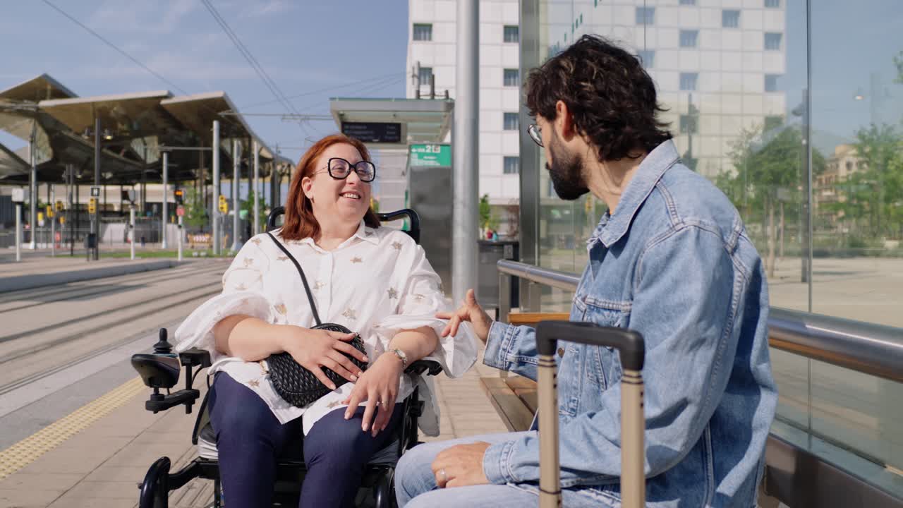Woman in wheelchair talking with a man at the train station