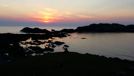 puesta de sol colorida en una playa rocosa