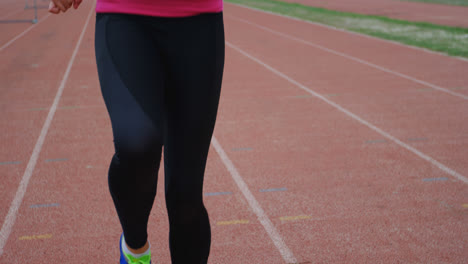 vista frontal de una atleta caucásica haciendo ejercicio en la pista de atletismo en un lugar deportivo 4k