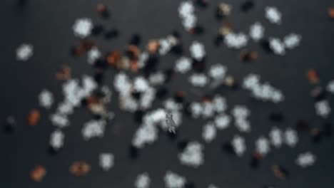 jigsaw puzzle pieces falling down in slow motion onto gray table with shallow close focus top down perspective depth of field out of focus