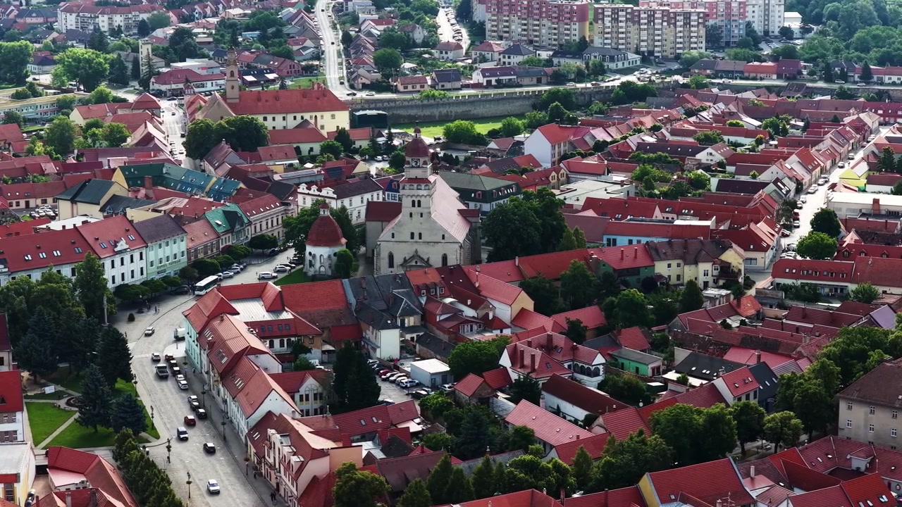 Letecký pohled z dronu na historické centrum Skalice, Slovensko. Tradiční červené střechy, kostelní věže, půvabné uličky a zachovalá architektura vytvářejí malebnou scénu na západním Slovensku.