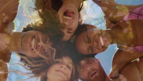 video compuesto de vista de bajo ángulo de un grupo diverso de amigos sonriendo contra árboles altos