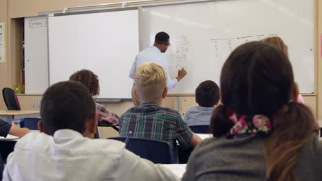 maestra tomando clase de matemáticas de quinto grado, vista trasera, filmada en r3d
