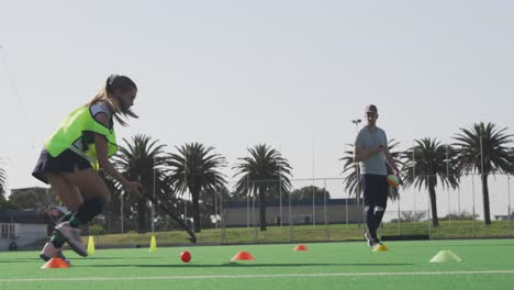 Female-hockey-player-training-on-a-field