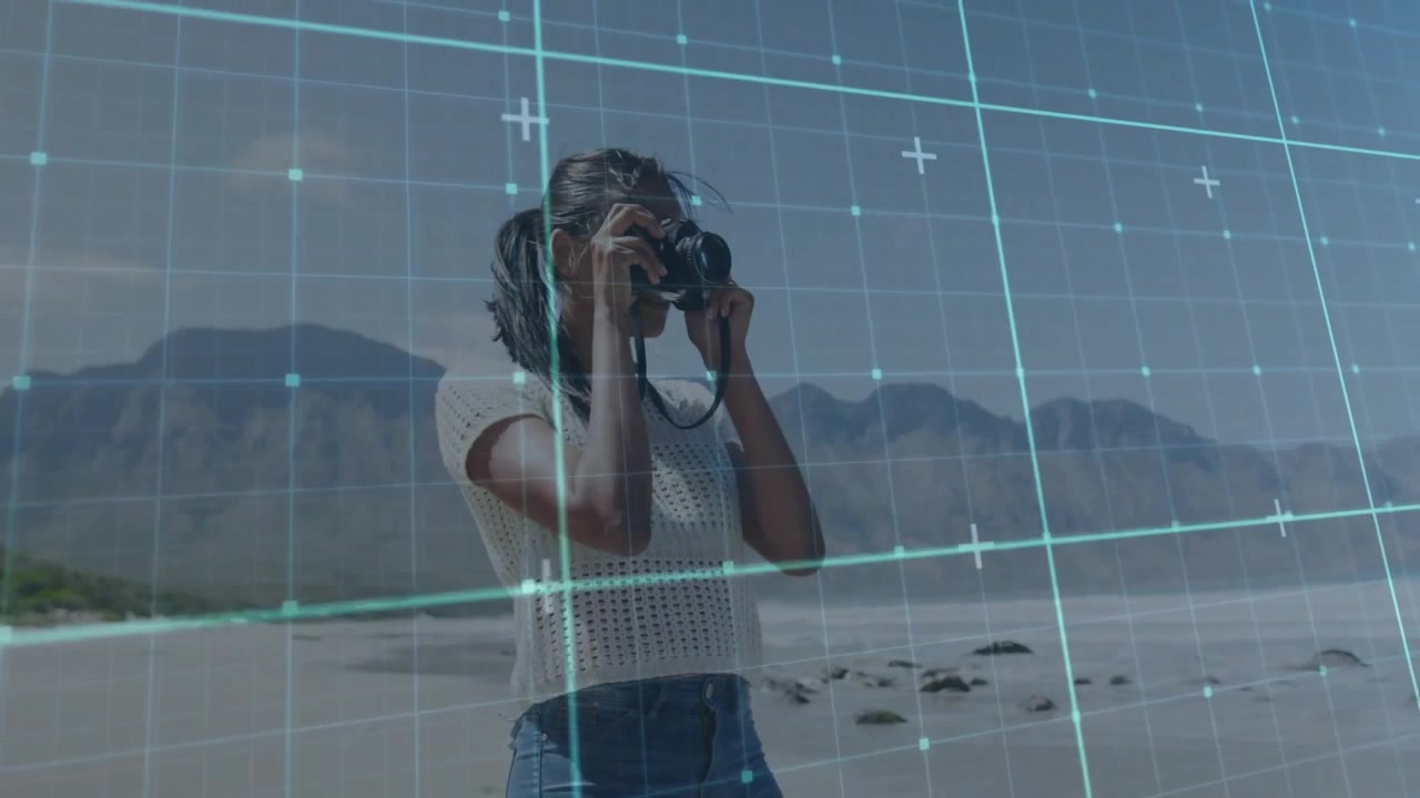 Kvindelig fotograf løfter DSLR og scanner kystlinjen for at komponere et billede med digitalt fokusgitter