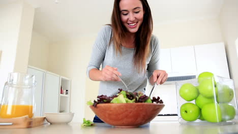 una bonita morena preparando una ensalada saludable