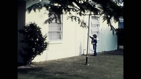 group of people standing outside a 1970s house in the usa. circa usa - 1970s: a snapshot of a group of people standing outside a house in 1970s america.