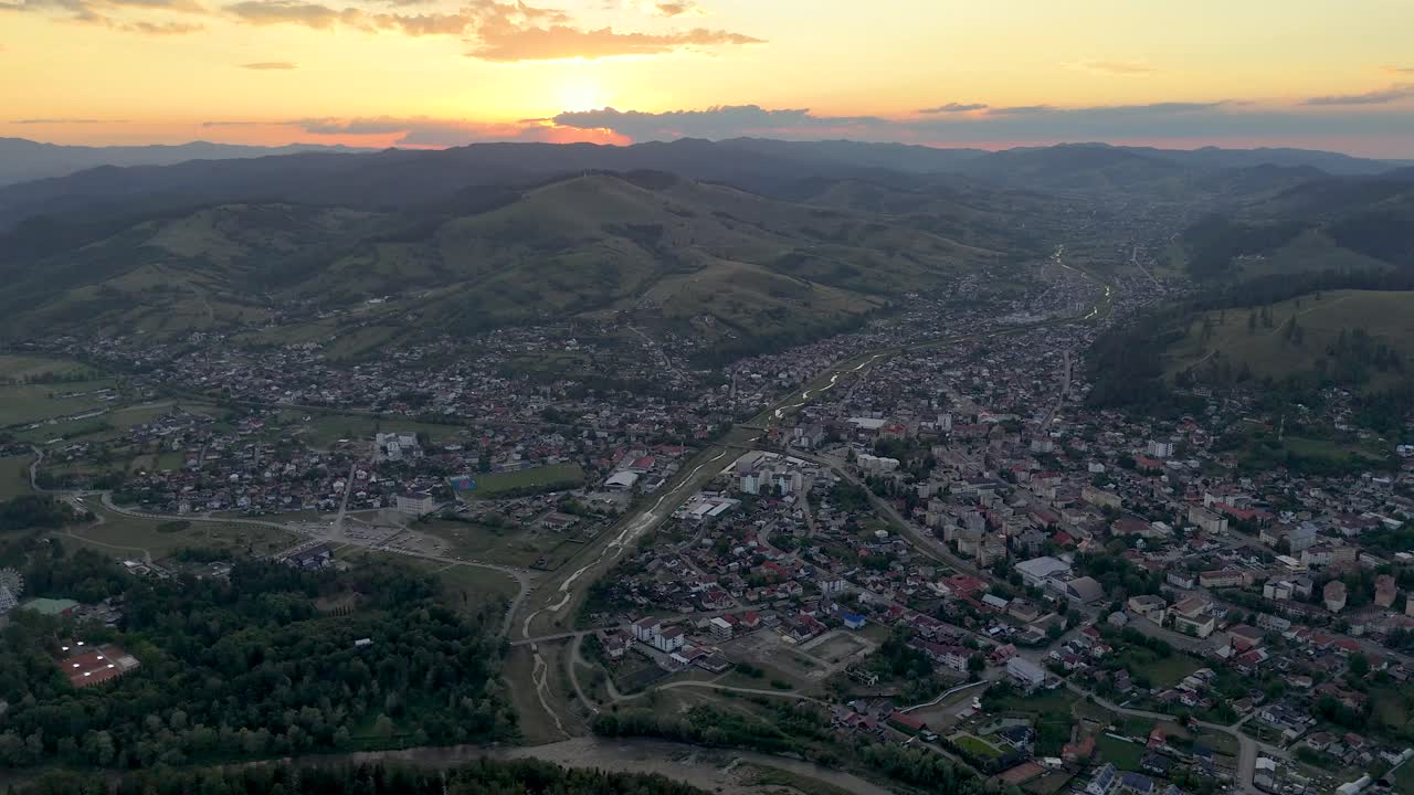 un dron captura una impresionante puesta de sol sobre el paisaje urbano y las colinas de gura humorului