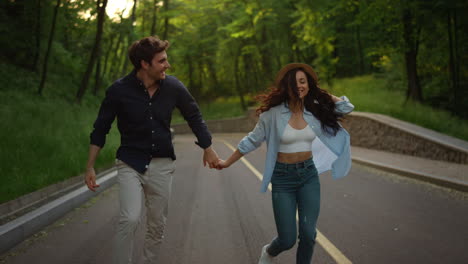 beautiful girl and guy jumping in park. young couple having fun outside