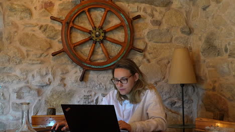 smiling blonde girl working remotely from a house decorated like a boat