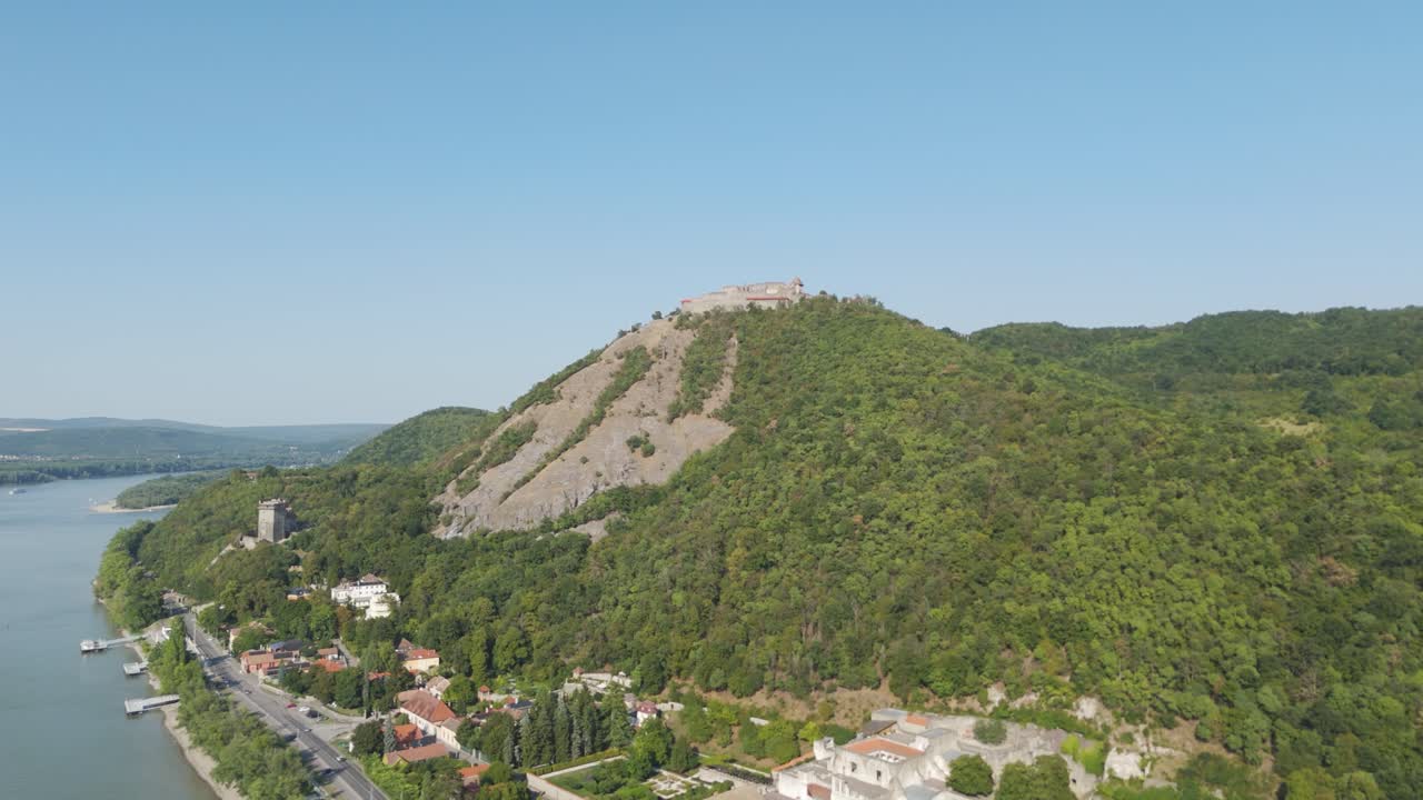 Scenic Aerial view flying toward the historic castle in Visegrád, Hungary, with surrounding hills