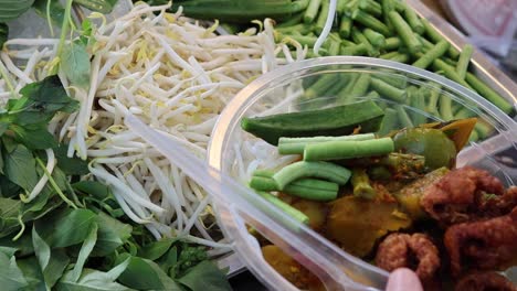 A vibrant display of fresh bean sprouts, herbs, and mixed vegetables in a culinary setting.