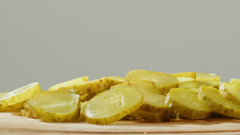 sliced dill pickles on a wooden board
