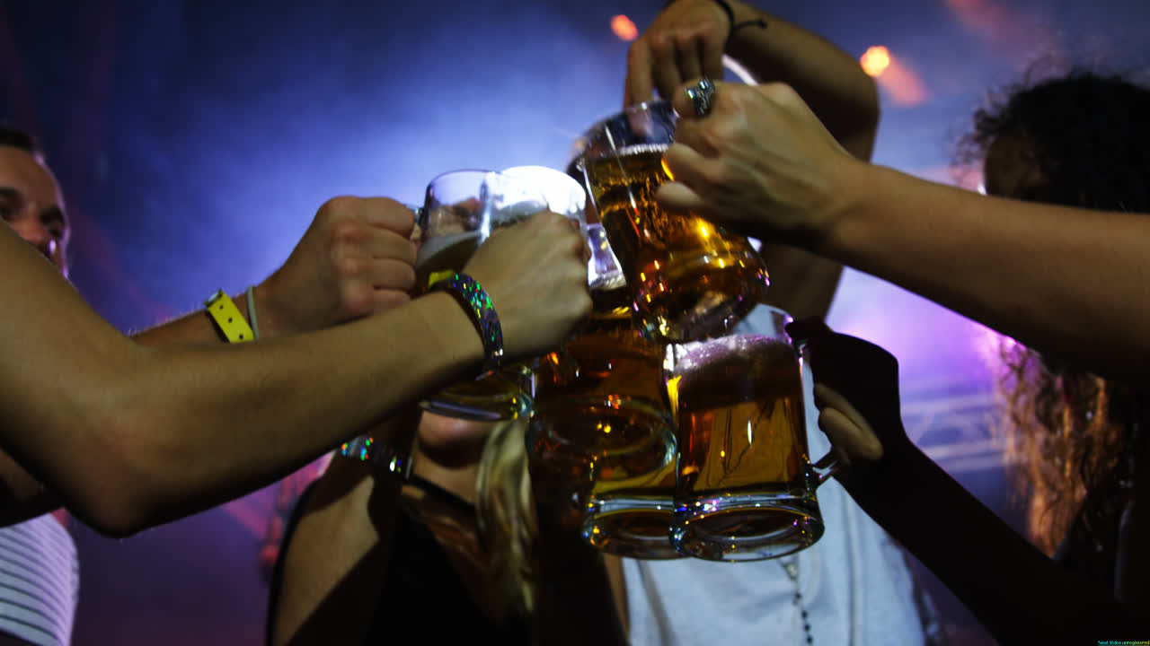 Gruppo di amici che brinda con boccali di birra a un concerto in 4K