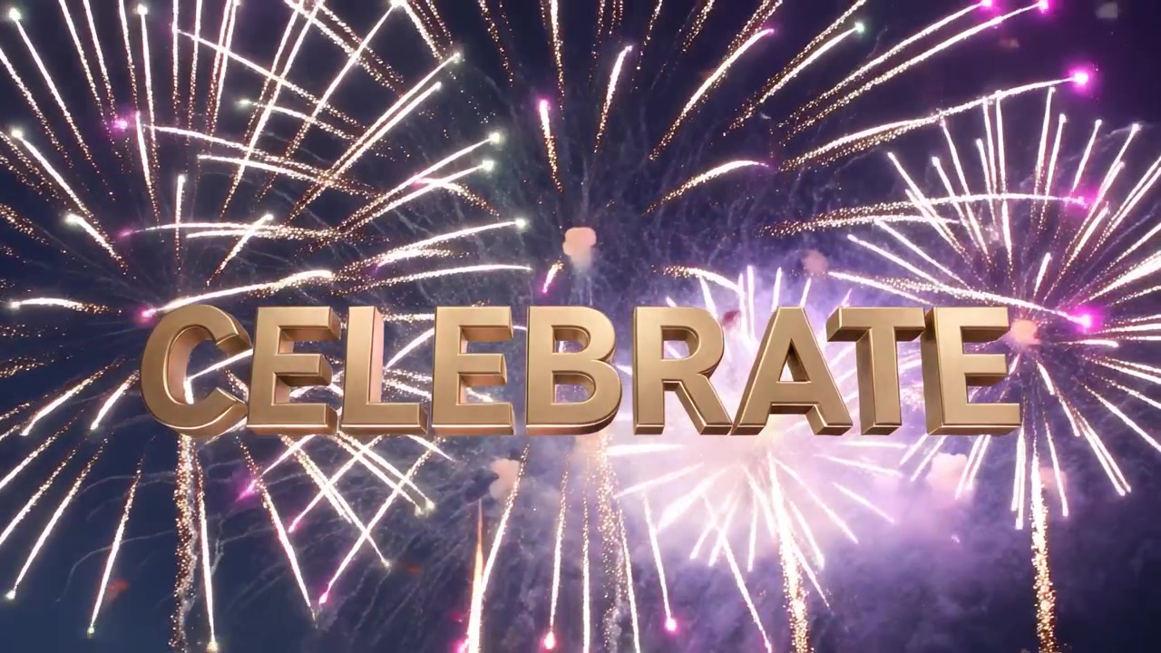 Il primo fuoco d'artificio scoppia dietro la scritta dorata "CELEBRATE" di notte, mentre i fuochi d'artificio creano una foschia festiva.