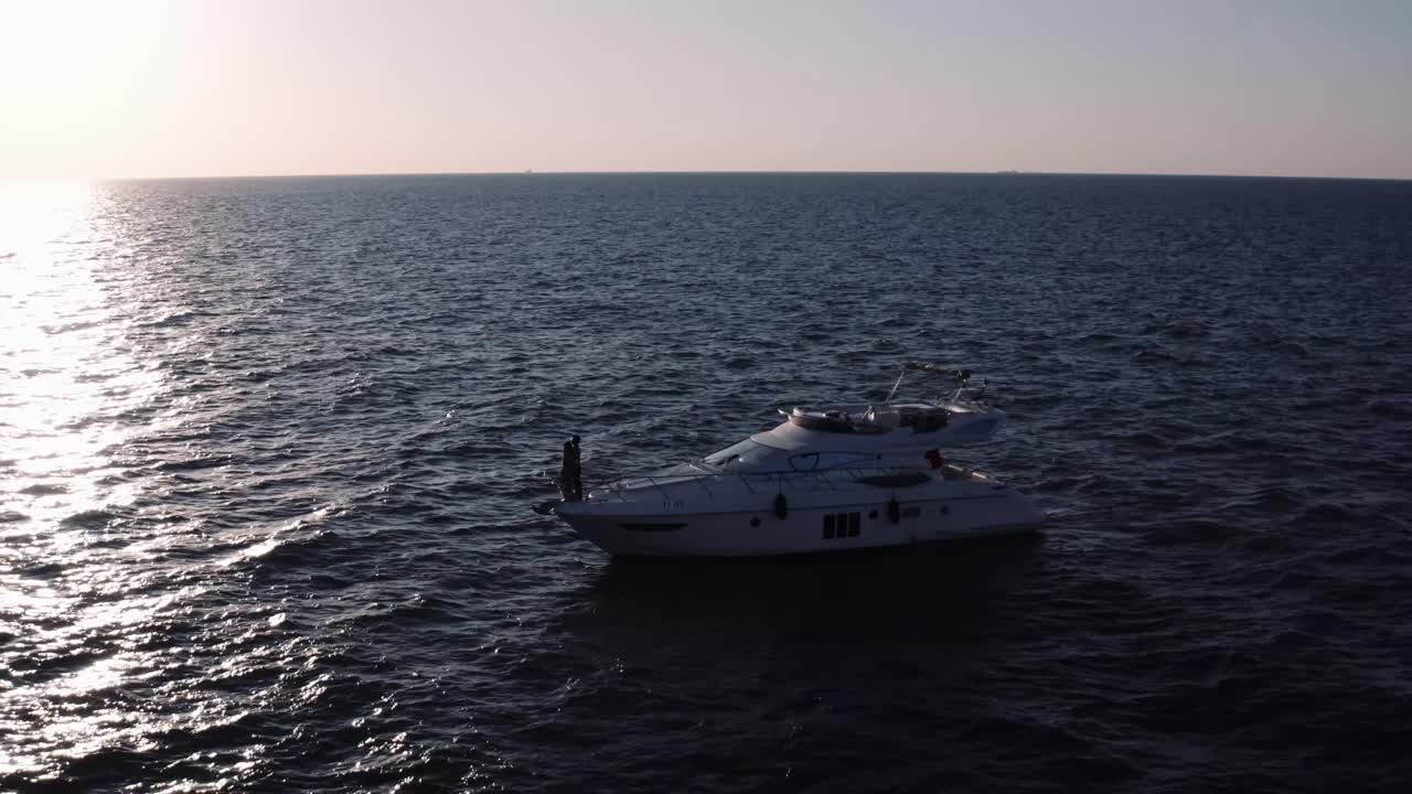 Una luna di miele perfetta su uno yacht in mare aperto al tramonto - ripresa aerea