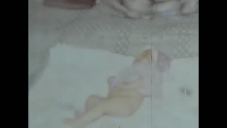 peaceful video of sleeping baby wrapped in a bed blanket. circa ussr 1980s: a beautiful photograph capturing the peacefulness as a baby sleeps soundly while wrapped in a cozy blanket on a bed.