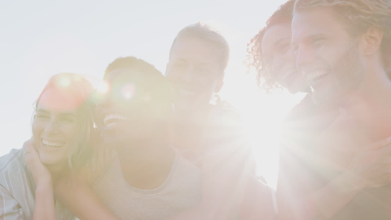 남자 들 이 여자 들 을 에 들고 친구 들 의 모임 으로 불타는 태양 을 향해 미소 짓는 것