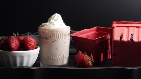 pink cocktail drink with strawberry liqueur, vanilla vodka and cream. party drink with strawberries. fruit cocktail with fresh strawberries as a garnish. cold and refreshing