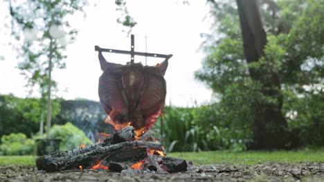 Aufnahme-Aus-Niedrigem-Winkel---Kleines-Feuer-Mit-Traditionellem-Langsamen-Garen-Von-Lammfleisch-Auf-Asado-Kreuz