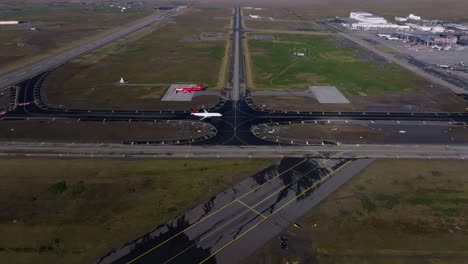 airplane arriving and taxiing towards iceland airport terminal, aerial